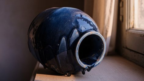 hero-16 Vase en céramique bleu marine glacé photographié en gros plan, lumière rasante mettant en avant les reliefs de la glaçure.