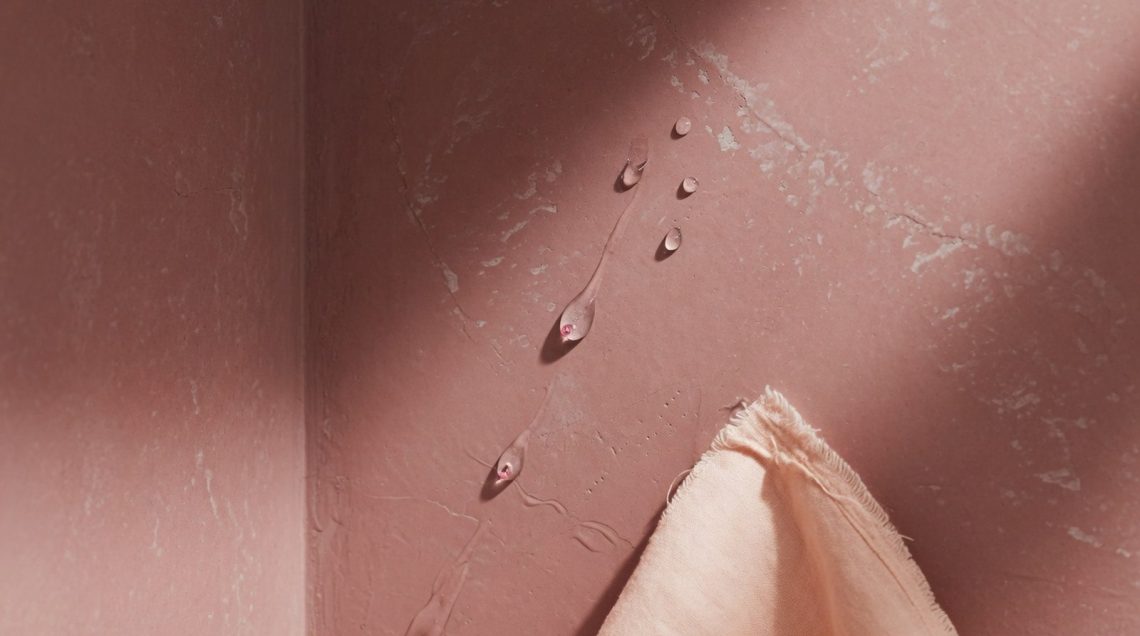 Coin de mur de douche rose poudré avec finition mate texturée et gouttes d'eau perlant